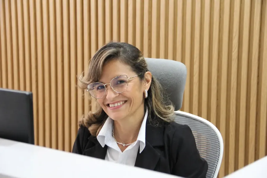 Colaboradora de SGI sonriendo en su puesto de trabajo